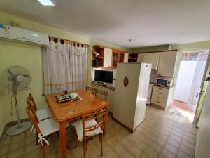 a kitchen with a wooden table and a refrigerator at CASA BARRIO SOMISA in San Nicolás de los Arroyos