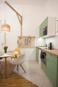 a kitchen with green cabinets and a table with a chair at Plan A in Budapest