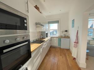 a kitchen with a sink and a stove top oven at Sandy Toes - awesome beach view and access in Ventnor