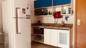 uma cozinha com armários brancos e um frigorífico em Apartamento linda vista no Brisas do Lago, Brasília em Brasília
