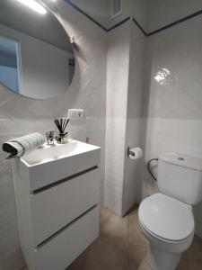 een witte badkamer met een toilet en een wastafel bij Estudio 42 in Ayamonte