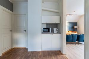 uma cozinha com armários brancos e uma sala de estar em Villa Svolvær em Svolvær