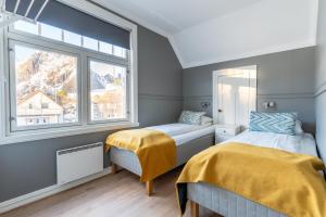 two beds in a room with a window at Villa Svolvær in Svolvær