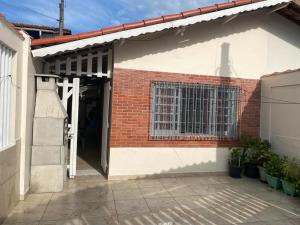 une porte ouverte d'un bâtiment en briques avec une fenêtre dans l'établissement Casa do lado da praia, 100 metros da praia., à Mongaguá
