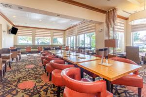 una sala de conferencias con mesas de madera y sillas rojas en Hilton Garden Inn Chicago/Tinley Park, en Tinley Park