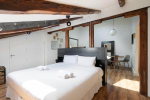 1 dormitorio con 1 cama blanca grande y toallas. en apartamento en alonso martinez, en Madrid