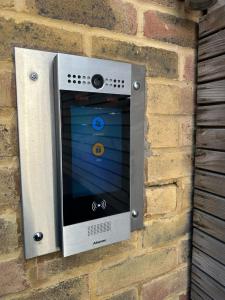 a microwave mounted on a brick wall at Luxury 1 bedroom Apartment in London overseeing Canary Wharf with free parking in London