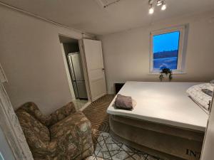 een slaapkamer met een bed, een stoel en een raam bij Relax Place in Svalöv