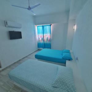 ein Zimmer mit einem blauen Bett und einem Fenster in der Unterkunft Hotel Ixtazihua JP in Zihuatanejo