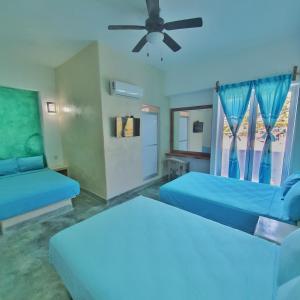 ein Schlafzimmer mit zwei Betten und einem Deckenventilator in der Unterkunft Hotel Ixtazihua JP in Zihuatanejo