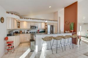 a kitchen with white cabinets and bar stools at Inviting Great Falls Home with Wraparound Deck! in Great Falls