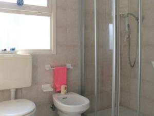 a bathroom with a toilet and a glass shower at Cozy oasis for families-Beahost in Bibione +21 photos