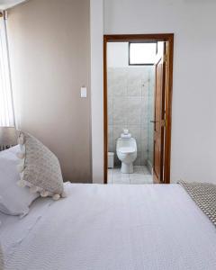 um quarto com uma cama e um WC na casa de banho em HOTEL AYRE By Baltra em Puerto Ayora