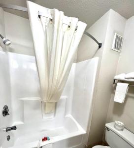 een badkamer met een bad en een douche met een gordijn bij Econo Lodge Oacoma in Oacoma