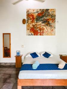 a bedroom with a bed with a painting on the wall at Hotel il Padrino in Granada +23 photos