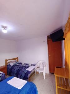 1 dormitorio con 2 camas, silla y escritorio en Hacienda Norabuena, en Recuay