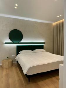 een slaapkamer met een groot bed met een groen hoofdeinde bij INCASSO CITY CENTER APARTMENT in Tirana