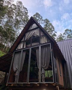 Casa pequeña con ventana grande en la parte delantera en Chalé Romântico com cachoeira, en Witmarsum