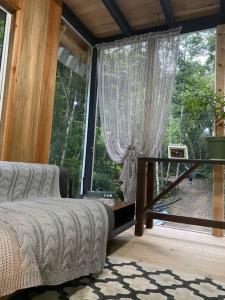 1 dormitorio con cama y ventana grande en Chalé Romântico com cachoeira, en Witmarsum