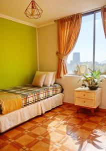 a bedroom with green walls and a bed and a window at Portugal L y D in Santiago