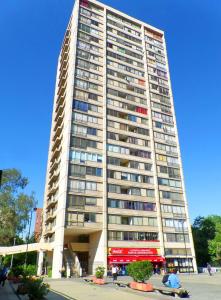 a tall apartment building with people sitting in front of it at Portugal L y D in Santiago
