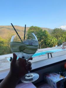 a person holding a martini glass in front of a window at Trip Monkey del Río in San Gil