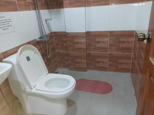 a bathroom with a white toilet and a shower at Angel Wish Guesthouse in El Nido