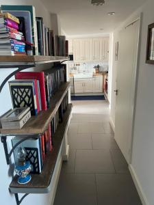 a kitchen with a book shelf filled with books at 2 bed/2 bath luxury flat with city view! in London