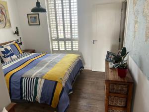 a bedroom with a bed with a striped blanket and a window at 2 bed/2 bath luxury flat with city view! in London