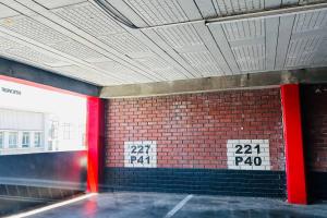 Zimmer mit roten Säulen und Ziegelwand in der Unterkunft 0.5 Studio Apartment at Paarl CBD in Paarl