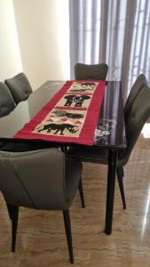 uma mesa e cadeiras com uma toalha de mesa em cima em Ellyz Home Stay em Moshi