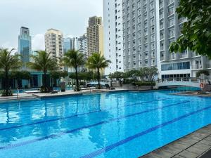 une grande piscine dans une ville avec de grands bâtiments dans l'établissement Stonewood Suites in Jazz Residences Makati 2x bigger unit, à Manille