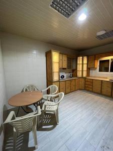 une chambre avec une table et des chaises dans une cuisine dans l'établissement شقة غرفتين ومطبخ Apartment, à Al Rass
