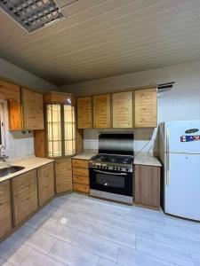 Il comprend une cuisine équipée d'une cuisinière et d'un réfrigérateur. dans l'établissement شقة غرفتين ومطبخ Apartment, à Al Rass