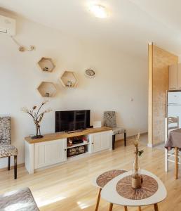ein Wohnzimmer mit einem TV und einem Tisch in der Unterkunft Apartments Kosta in Tivat