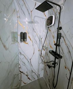 d'une douche avec un mur en marbre blanc. dans l'établissement Stonewood Suites in Jazz Residences Makati 2x bigger unit, à Manille