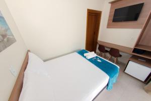 Kleines Zimmer mit einem Bett und einem TV in der Unterkunft Pousada Viva praia 30 metros da Praia in Penha