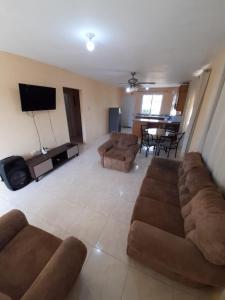 a living room with a couch and a tv at Seville Meadows 3 - Johns Road Spanish Town in Spanish Town