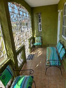 a balcony with two chairs and a stained glass window at Seville Meadows 3 - Johns Road Spanish Town in Spanish Town