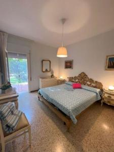 1 dormitorio con 1 cama y 1 silla en Elegant villa in a quiet area with garden en Bibione