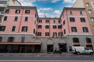 a group of pink buildings on a city street at Meraki Apartment in Milan