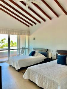 a bedroom with two beds and a large window at casa moderna con playa cartagena in Cartagena de Indias