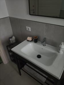 lavabo blanco en el baño con espejo en Maison de Famille, en Turín