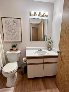 a bathroom with a toilet and a sink and a mirror at Quest Travels in Seattle