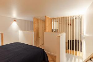 朗布依埃的住宿－L'Ermitage，一间卧室设有一张床和一个木制隔板