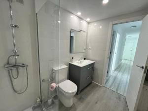 y baño con aseo, ducha y lavamanos. en H&H Apartamento Azucena en Granada