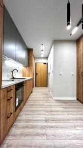 a kitchen with wooden cabinets and a tile floor at Modern Apartment in Krakow