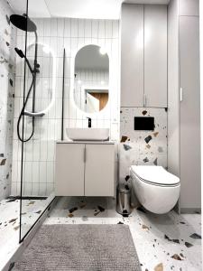 a bathroom with a toilet and a sink and a mirror at Modern Apartment in Krakow