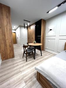 a room with a table and a chair and a bedroom at Modern Apartment in Krakow