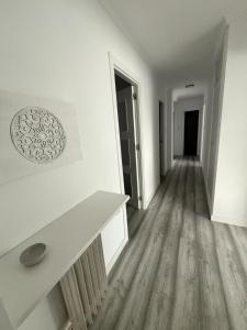 Habitación vacía con paredes blancas y suelo de madera. en H&H Apartamento Azucena en Granada